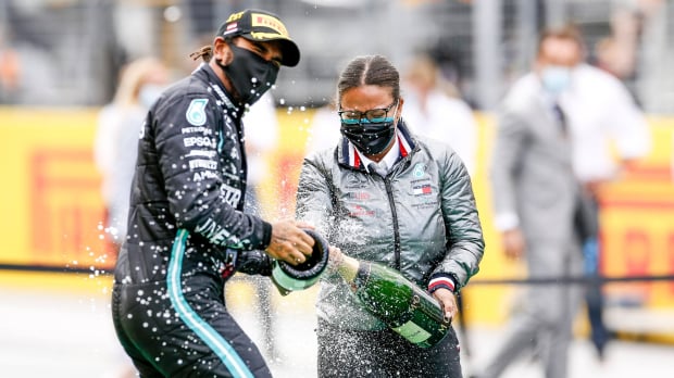 Lewis Hamilton and Stephanie Travers celebrating on the podium at the 2020 Grand Prix of Styria