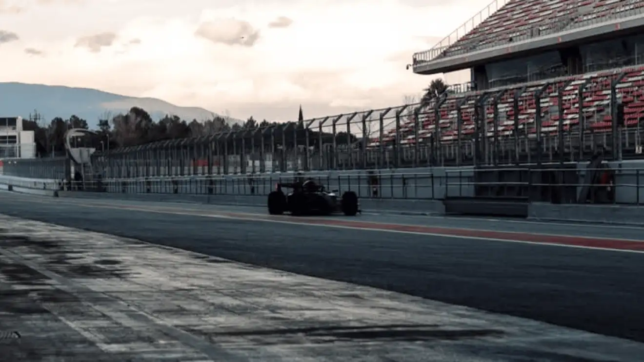 The Audi F1 2026 car making its way down a darkly lit Barcelona pit lane